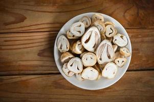 straw mushrooms on white plate, fresh mushrooms slice for cooking food - top view photo