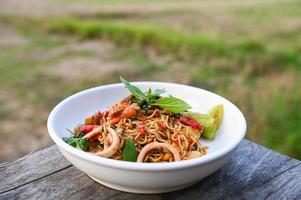noodles plate with instant noodles stir fried with vegetables herb spicy tasty appetizing asian noodles mix seafood stir fried squid with basil and chilli pepper photo