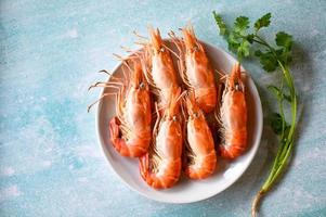 cooking shrimp food on white plate background dining table food, Fresh shrimps prawns seafood lemon lime with herbs and spice photo