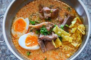 curry bone soup - bone soup pork with boiled eggs in hot pot, Thai food tom yum hot and sour soup