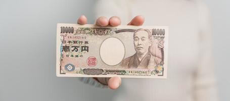 Woman hand holding Japanese Yen banknote stack. Thousand Yen money. Japan cash, Tax, Recession Economy, Inflation, Investment, finance and shopping payment concepts photo