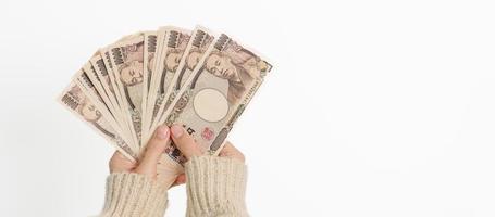 Woman hand holding Japanese Yen banknote stack. Thousand Yen money. Japan cash, Tax, Recession Economy, Inflation, Investment, finance and shopping payment concepts photo