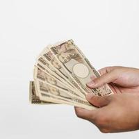 man hand holding Japanese Yen banknote stack. Thousand Yen money. Japan cash, Tax, Recession Economy, Inflation, Investment, finance and shopping payment concepts photo