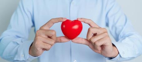 man hand holding red heart shape. love, donor, world heart day, world health day and Insurance concepts photo