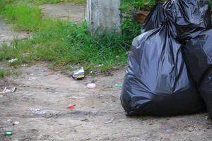 Pile black garbage bag roadside in the city photo