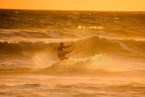 kitesurfer a puesta de sol foto