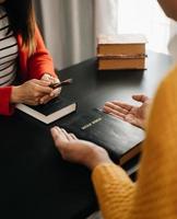 dos personas leyendo y estudiando la biblia en casa y rezando juntas. estudiando la palabra de dios con amigos. foto