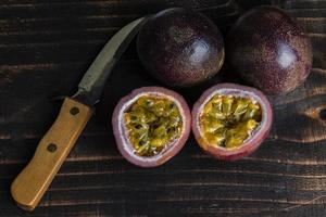 comida vegetariana saludable fruta de la pasión en la mesa de madera negra de cerca. foto