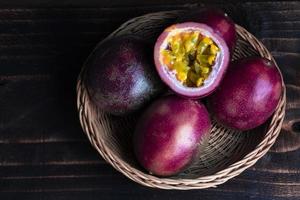 vegetariano sano comida pasión Fruta en cesta en negro madera mesa cerca arriba. foto