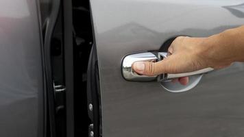 Driver's hand pulls the car door. Gray luxury car. photo