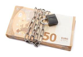 Lock security and chain on euro stack banknotes isolated on white background. Monetary crisis, financial problems, default concept photo