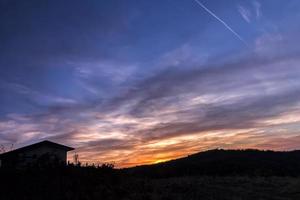 silhouette of a mountain house at amazing sunset photo