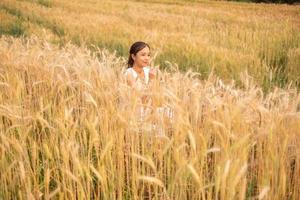 joven asiático mujer en blanco vestidos en el cebada arroz campo foto