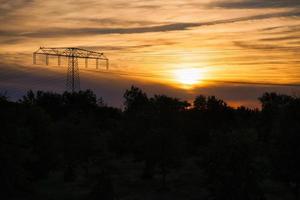 High-voltage power pole with overhead line through which the electricity is transported photo