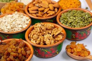 Healthy vegetarian food concept. Assortment of dried fruits, nuts and seeds on white background. Top view. photo