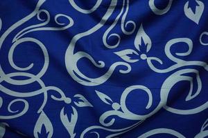 Bright blue background with batik ornaments such as flowers photo