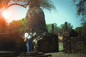 couples of asian woman standing in old temple of ayutthaya and  looking on smart phone screen ,ayuttha is one of most popular traveling destination in thailand photo