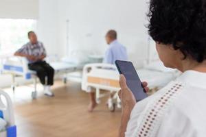 nursing home care concept. Elderly Woman Using A Mobile Telephone. looking at camera photo