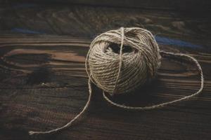 brown wool yarn ball isolated on wooden background. ball of yarn for knitting photo