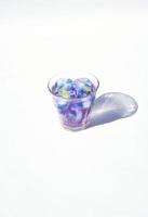 glass of purple tea with ice cube on white background photo