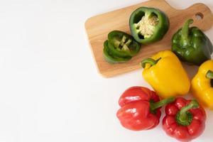 Top view of cutting sweet bell pepper on the wooden board isolated on white background. photo