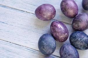 Happy Easter greeting card with eggs in trendy purple very peri color on a wooden background. Natural dye karkade tea. photo