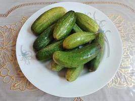 Fresco Pepino en un plato a mesa foto