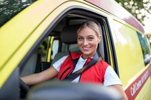 Ambulance staff members in her ambulance. She is wearing ambulance uniform of paramedics. She is sitting in the ambulance ready to go to a call photo