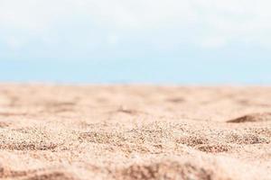 hermosa playa con amarillo arena con pequeño guijarros, desenfocado azul cielo en soleado día. panorámico vista. natural antecedentes para verano vacaciones. Copiar espacio foto