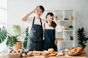 Asia amantes o parejas Cocinando en cocina con lleno de ingrediente con un pan y fruitón mesa.valentines día foto