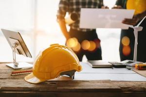 Construction team shake hands greeting start new project plan behind yellow helmet on desk in office to consults about their building project.. photo