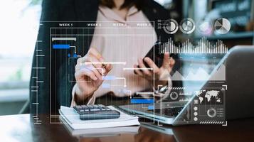 Businessman hand Project manager working and update tasks and Gantt chart scheduling virtual diagram.with smart phone, tablet and laptop in office. photo