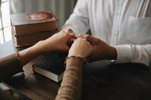 dos personas leyendo y estudiando la biblia en casa y rezando juntas. estudiando la palabra de dios con amigos. foto