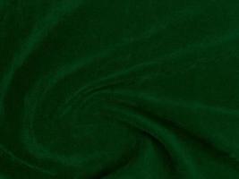 textura de tela de terciopelo verde oscuro utilizada como fondo. fondo de tela verde vacío de material textil suave y liso. hay espacio para el texto. foto