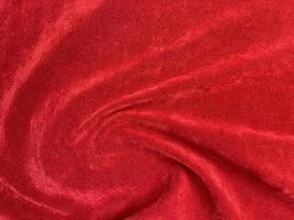 textura de tela de terciopelo rojo utilizada como fondo. fondo de tela roja vacía de material textil suave y liso. hay espacio para el texto.. foto