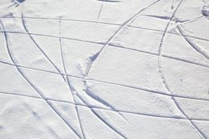 Skate tracks on ice with snowy snow. Winter background. photo