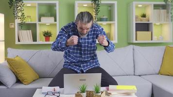 Surprised mature happy businessman receiving gospel mail message. Excited very happy mature man celebrating success looking at laptop sitting at home. Victory and success concept video