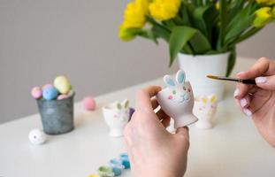 Woman colors easter decorations. Bunny shaped holders in pastel colors photo