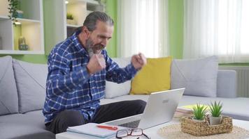 gammal man arbetssätt från Hem på bärbar dator är läsning Bra Nyheter och fröjd. överraskad Lycklig affärsman tar emot e-post meddelande eller Nyheter läsning Bra Nyheter, dans, njuter han själv. video