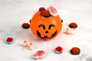 Halloween banner with trick or treat concept.Jack'o'lantern shaped candy bowl wit delicios scaru sweets. photo