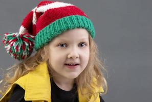 gracioso pequeño niña en un Navidad sombrero. retrato de un alegre y contento niño. foto