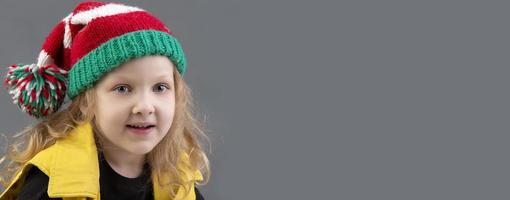 gracioso pequeño niña en un Navidad sombrero. retrato de un alegre y contento niño. foto
