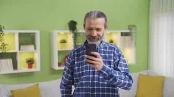 sorridente vecchio uomo avendo un' piacevole e divertimento tempo su smartphone. vecchio uomo utilizzando smartphone è visualizzazione sociale media messaggi, sms, giocando Giochi. video