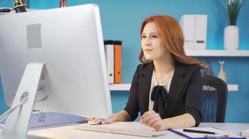 negocio mujer trabajando a el computadora es satisfecho con qué ella ve en el pantalla. alegría negocio mujer. negocio mujer trabajando en su oficina es satisfecho con qué ella ve en el computadora. video