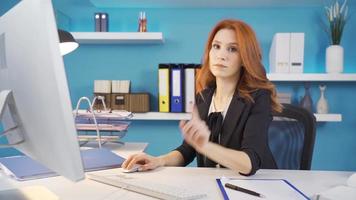 negocio mujer trabajando con computadora mirando a cámara y haciendo 'No' signo. mujer de negocios trabajando en su oficina mirando a cámara y haciendo un negativo signo. video