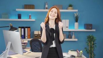 attività commerciale donna gioia e guardare a telecamera. gioia donna d'affari nel sua ufficio riflette sua emozione guardare a il telecamera. video