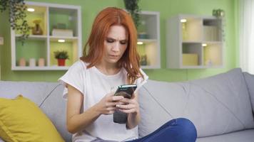 Frustrated and unhappy woman texting on the phone at home. The woman who broke up with her lover is texting on the phone at home in an angry and unhappy way. video