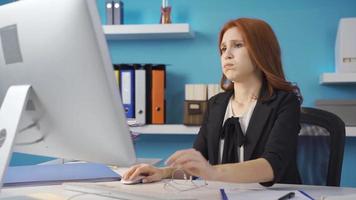 cansado o negócio mulher pega chateado quando ela vê a computador e continuou dela trabalhar. a mulher trabalhando a partir de a computador dentro a escritório é chateado de o que ela vê e continuou dela trabalhar. video