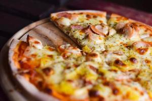 pizza hawaiian cheese on wood table. homemade food concept photo