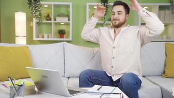 le homme qui travaux à Accueil est content lorsque il finitions le sien travail. Jeune homme travail de Accueil sur en ligne portable finition le sien travail et étant heureux. video